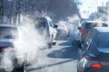 Cars in traffic emitting smoke from their exhausts