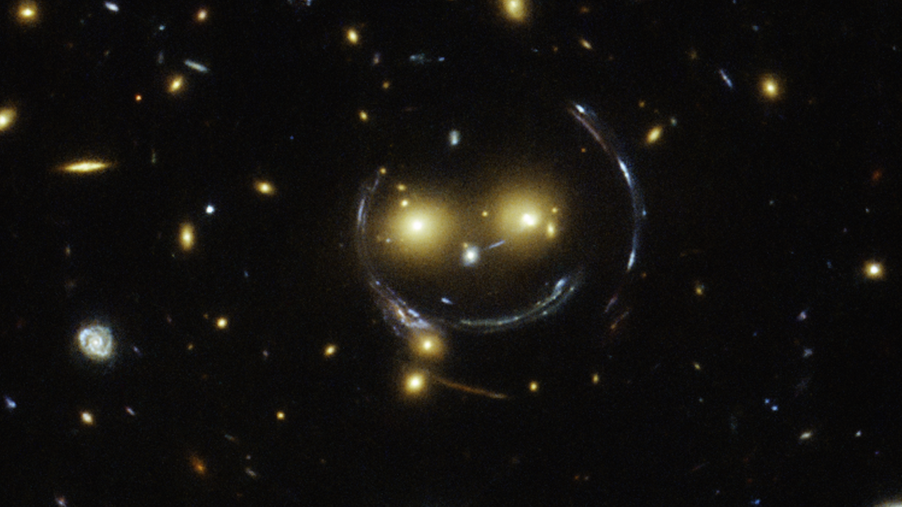 Two faint galaxies that feature image distortions caused by an effect known as strong gravitational lensing. This phenomenon can be explained by Einstein’s theory of general relativity.