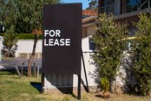 For lease sign on a black display outside of a resedential building in Australia. Investment property real estate