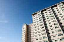 Photograph of a public housing apartment against a blue sky.