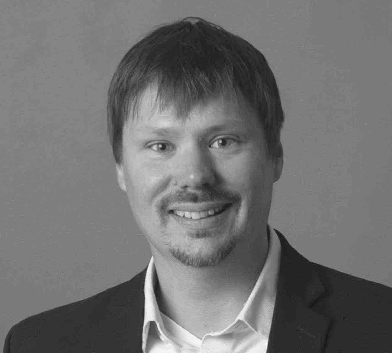 Black and white image of a man wearing black jacket and white shirt