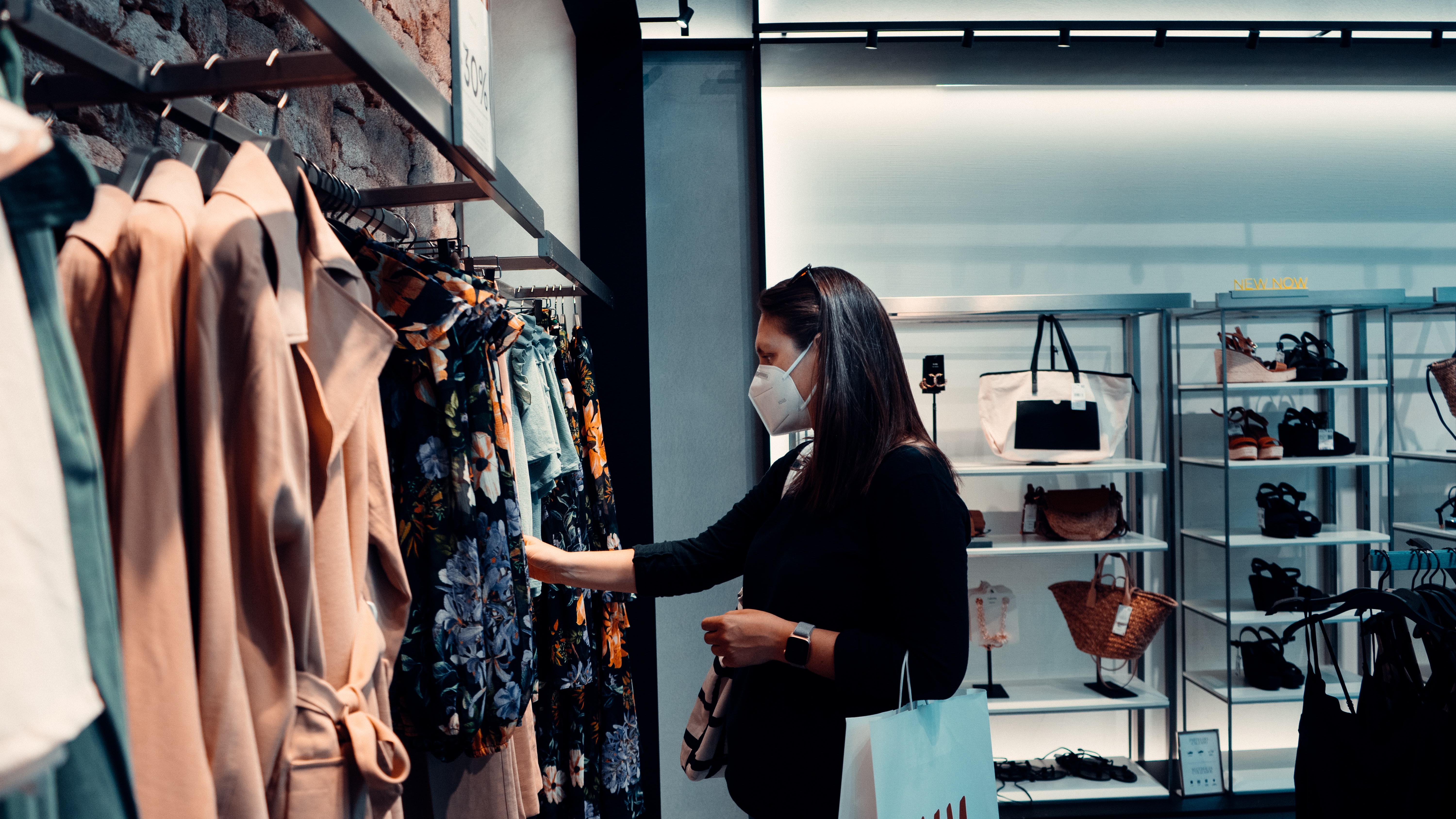 Woman browsing fashion retail with a mask on