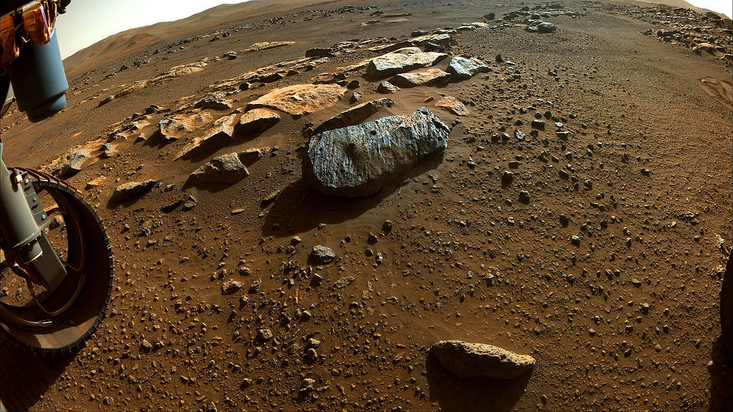This image taken by NASA's Perseverance rover on Sept. 7, 2021, PDT (Sept. 8, EDT), shows two holes where the rover's drill obtained chalk-size samples from rock nicknamed "Rochette." The hole on the left side is known as "Montagnac" (drilled on Sept. 7), and the hole on the right is known as "Montdenier" (drilled on Sept. 1). A round spot where the rover abraded part of the rock's surface, nicknamed "Bellegarde," is visible under the hole on the right. Tailings (or cuttings) from the Montdenier coring activity slid over Bellegarde.  This main image in which a rover wheel is visible was taken by one of Perseverance's Hazard Avoidance Cameras. A second image was taken by a Navigation Camera from a higher vantage point on the rover's mast. Both were taken on the 196th sol (Martian day) of the rover's mission and processed to enhance contrast.