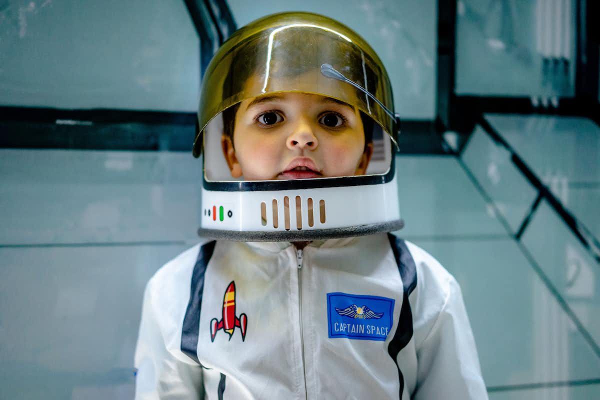 A boy wearing an astronaut suit. 