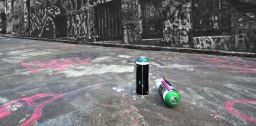 Two spraycans lying on the ground of a graffiti covered alleyway