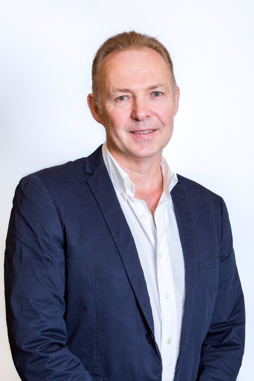 Portrait of man in navy suit and white button up shirt. 