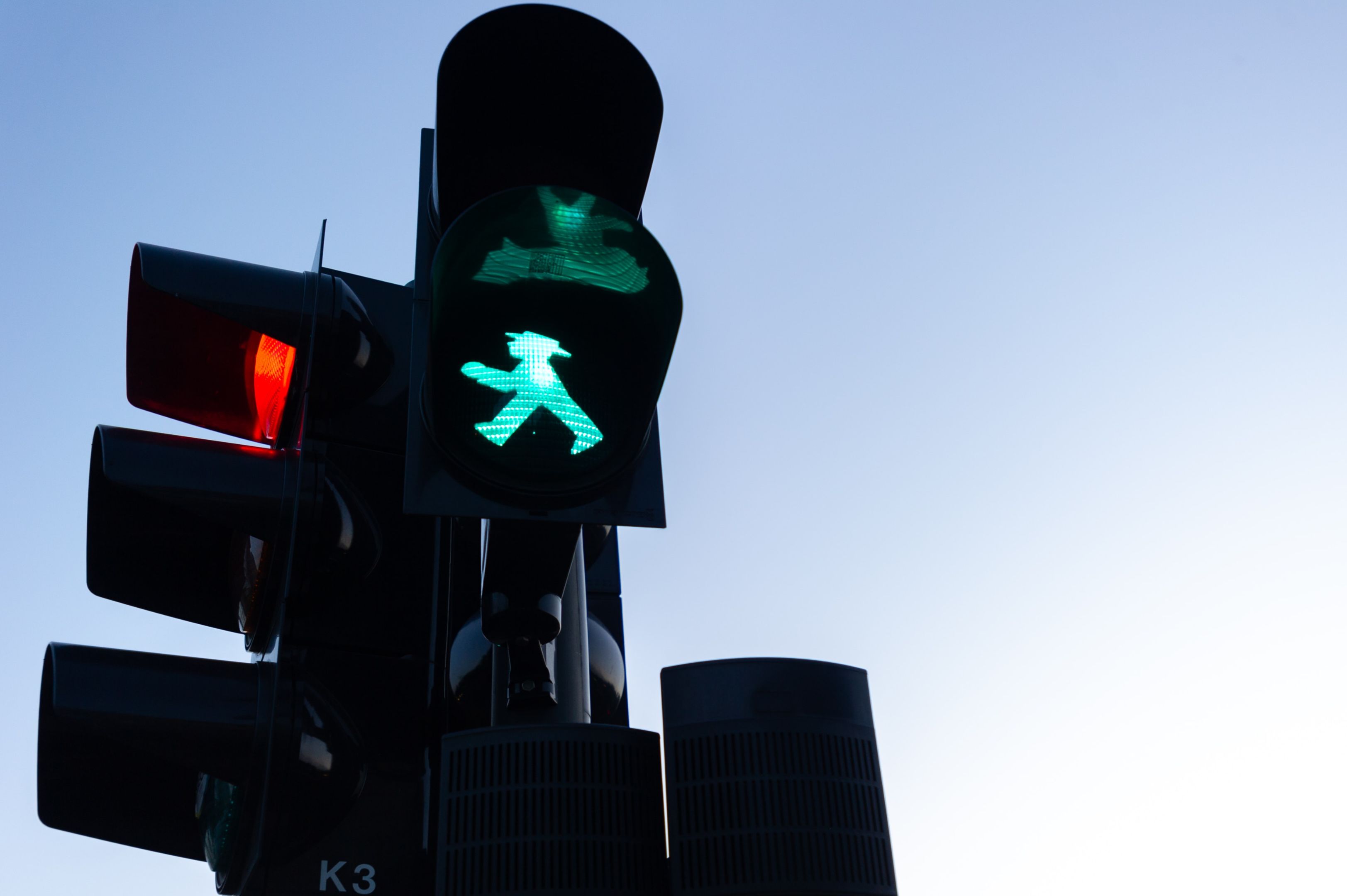 The walk symbol is lit up on a pedestrian crossing traffic light