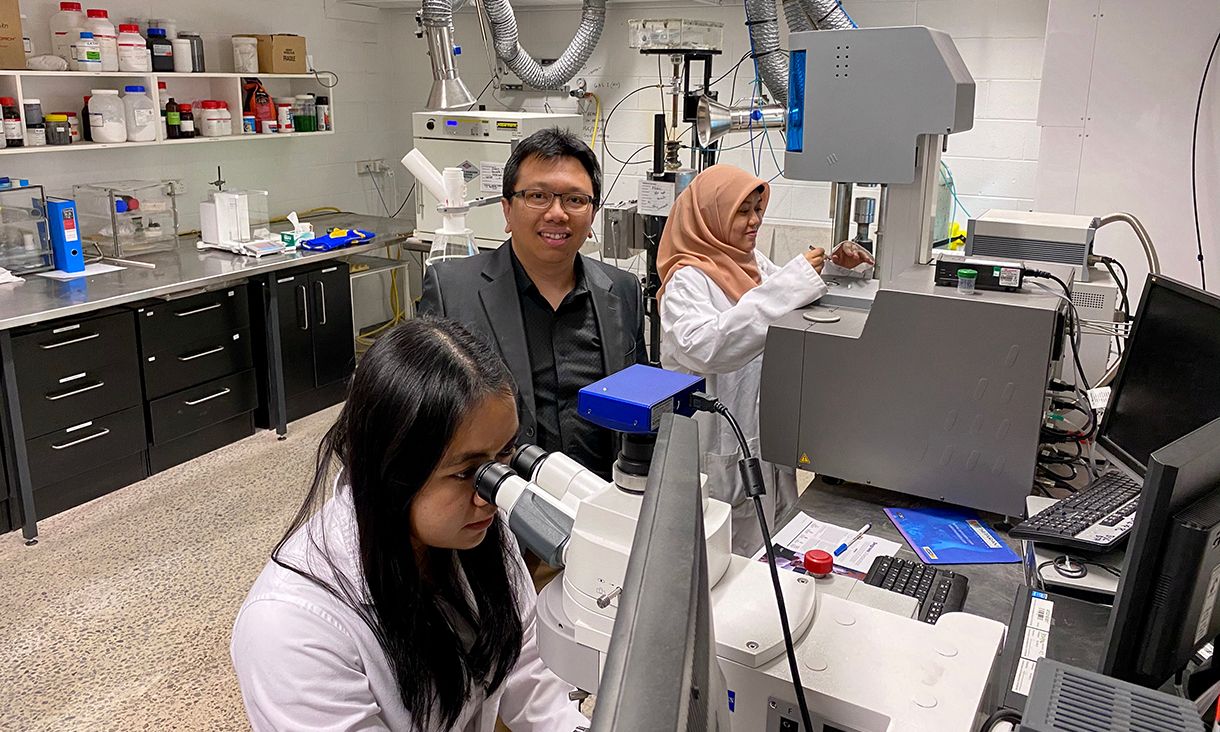 Professor Akbar Rhamdani in research lab with postgrad students Bintang Nuraeni (left) and Aulia Qisthi Mairizal (right)