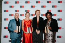 The three AIA event winners stand with Swinburne VC, all smiling. The winners hold trophies 