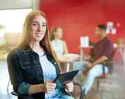 Confident female designer working on a digital tablet in red