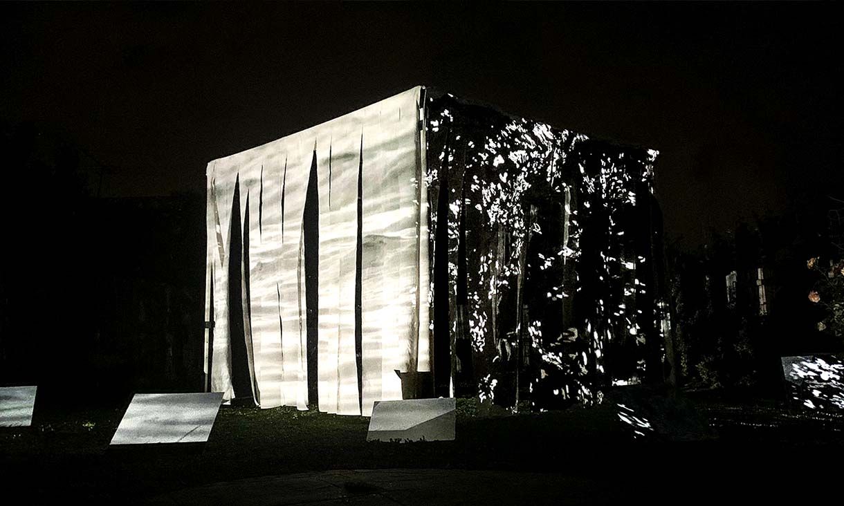 An immersive box shaped installation illuminate in a dark room