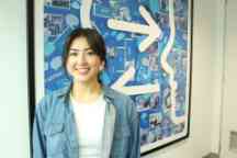 Swinburne professional placement student, Elysia, standing in front of a blue abstract artwork.