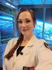 A female student in a Swinburne lab coat in front of a space background of earth 