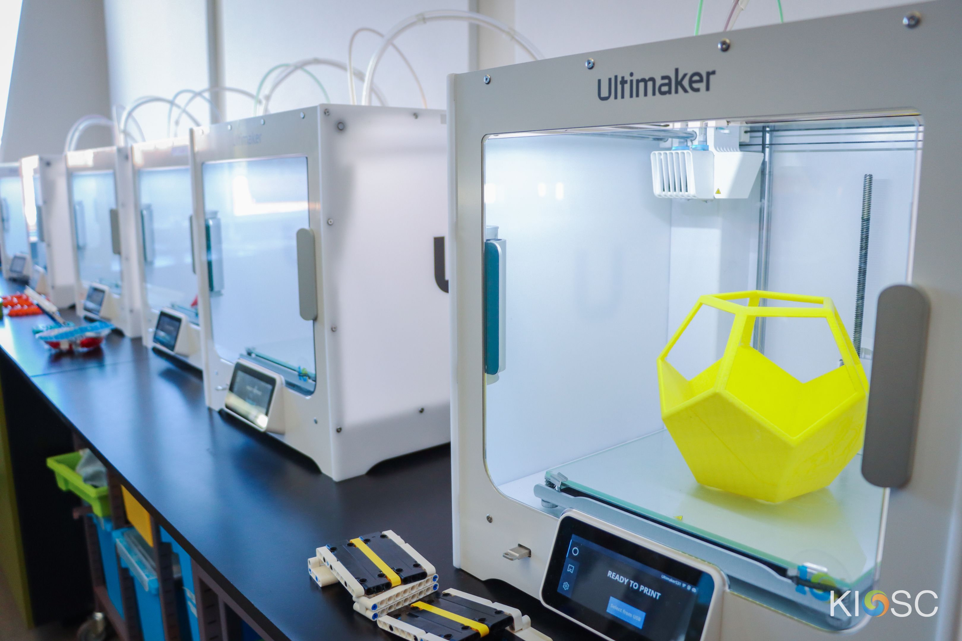 A bright yellow 'smart' pot plant holder sits inside a 3D printer at Swinburne's KIOSC