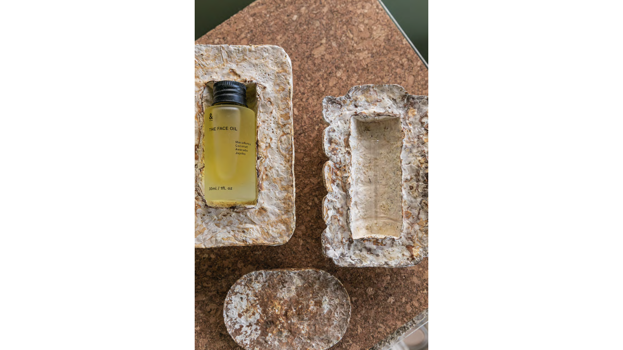 Mycelium packaging displayed holding a clear bottle of facial oil