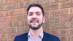 A photograph of Diploma of Business student Nicholas wearing a suit and smiling at the camera