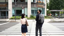 A woman and a man on a pedestrian crossing in Asia