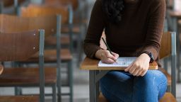 A female student on a chair working on an assessment