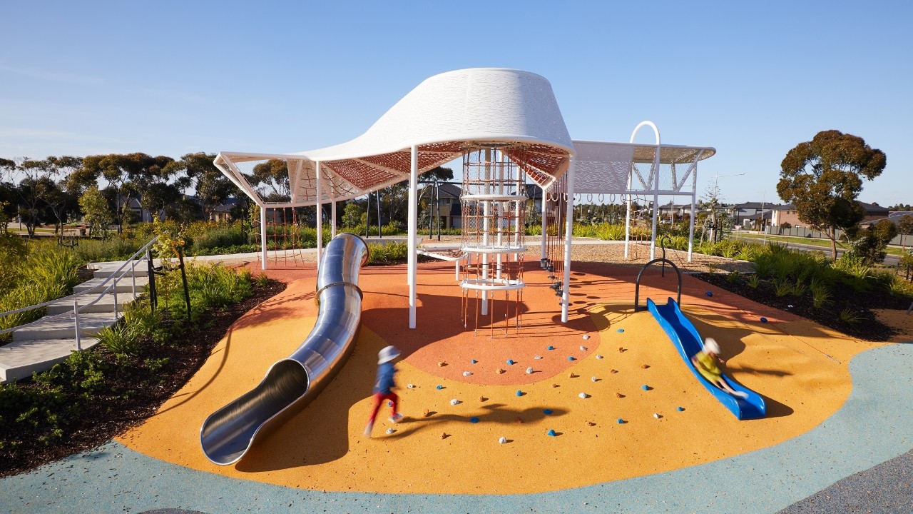 A large white curved play structure that you can climb through including slides and 