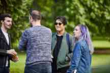 Four students chatting in the park and socialising