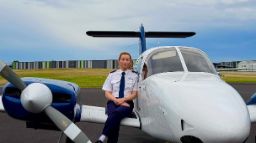 Woman outside witting on a small jet plane 
