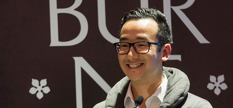 Swinburne student, Liem, at a lectern in front of Swinburne University branding.