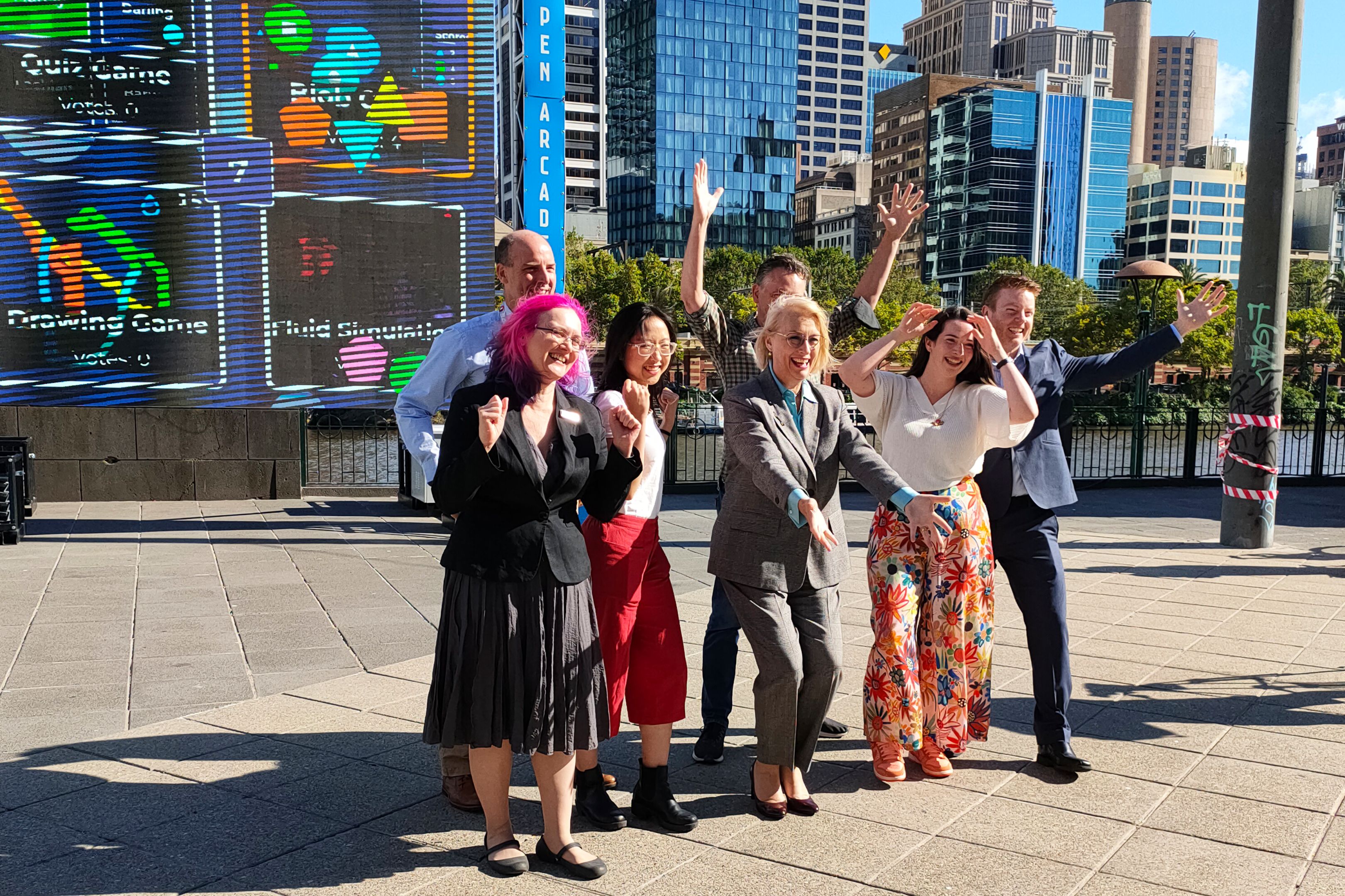 Swinburne staff and students, SAGE Automation staff and Lord Mayor Sally Capp celebrated the Open Arcade returning to Queensbridge Square with their arms up celebrating