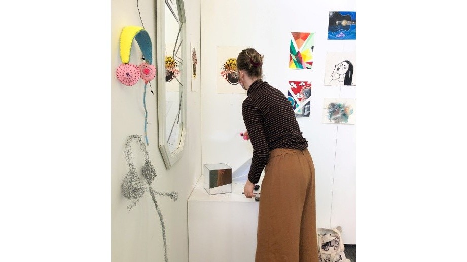 Student interacting with artworks in a gallery exhibition space.