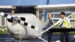 Two aviation students standing next to an airplane