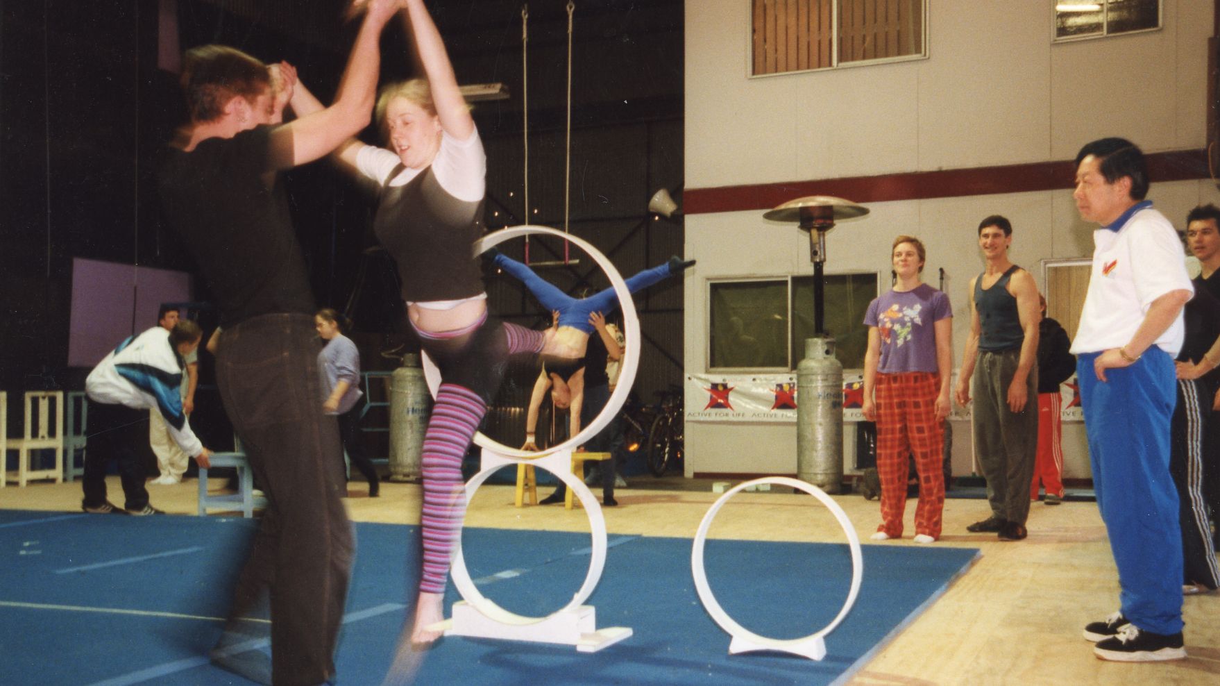 Circus performers practise in a warehouse
