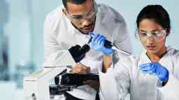 Male and female laboratory technicians conducting scientific tests.