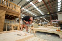 Carpentry student in a workshop cutting wood for a cubby house