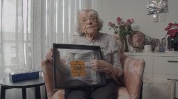 Esther Wise in N'Ouiblez Jamais holding the Jewish Star that was given out during WWII. 