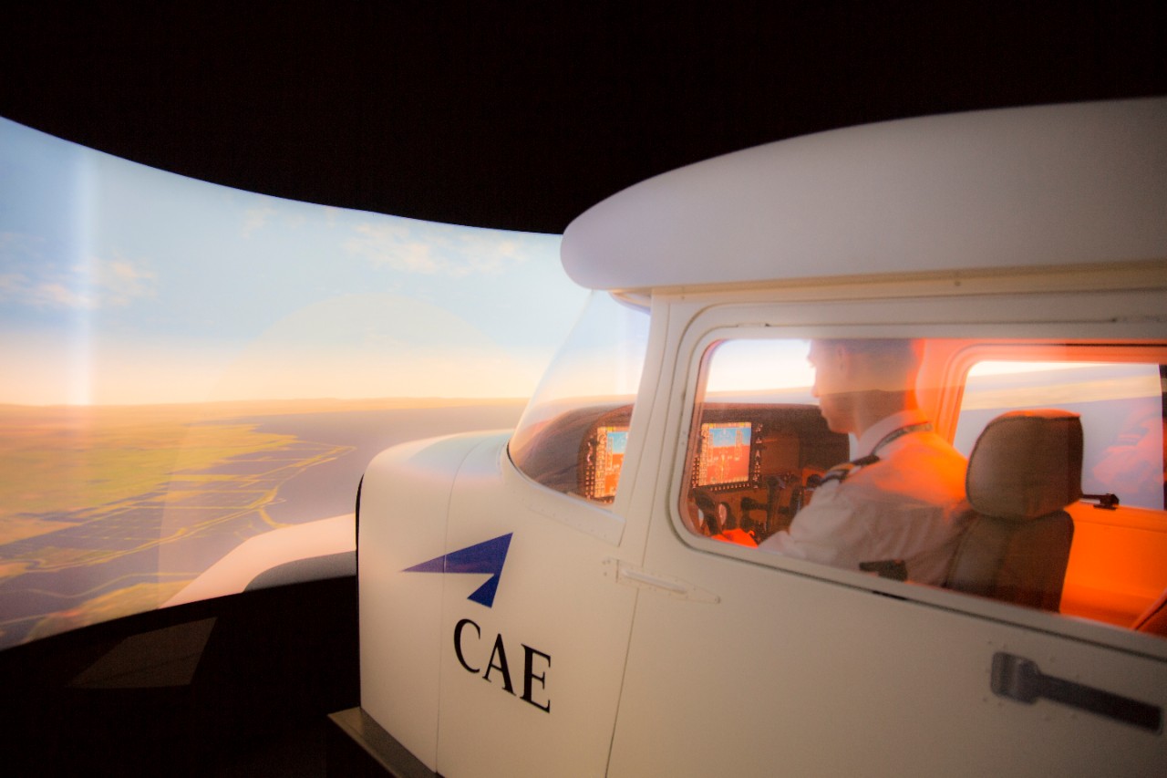 A professional piloting degree student fly a plane in the aviation flight simulator 