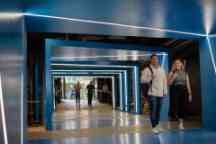 Blue hallway under the BA building with students walking