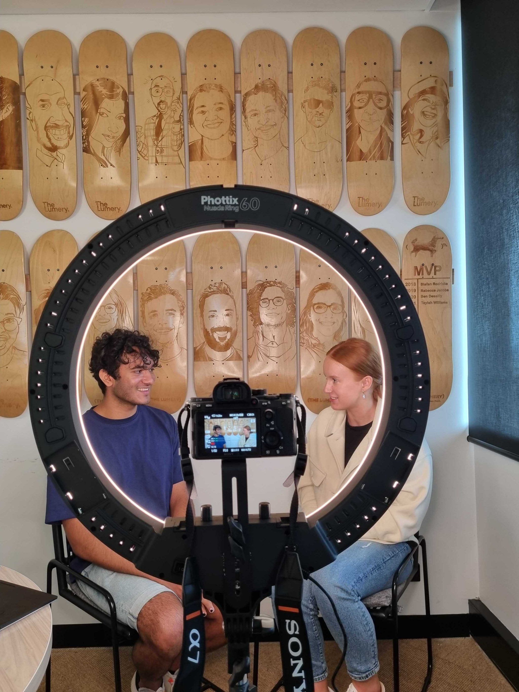 Student Olivia recording a video with her colleague in front of a camera and a ring light