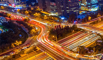 CIC - Smart Cities Research Institute representation: a busy city road intersection at night