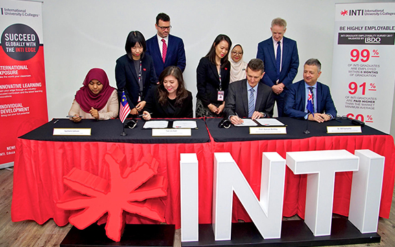 Swinburne and INTI staff signing agreement