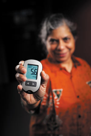 Professor Nilmini Wickramasinghe holding an electronic device