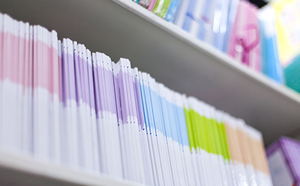 A number of books on a bookshelf in a library