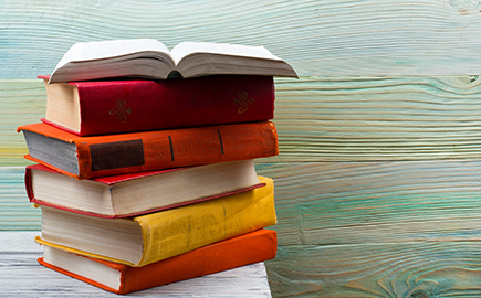 A pile of books sitting on a desk