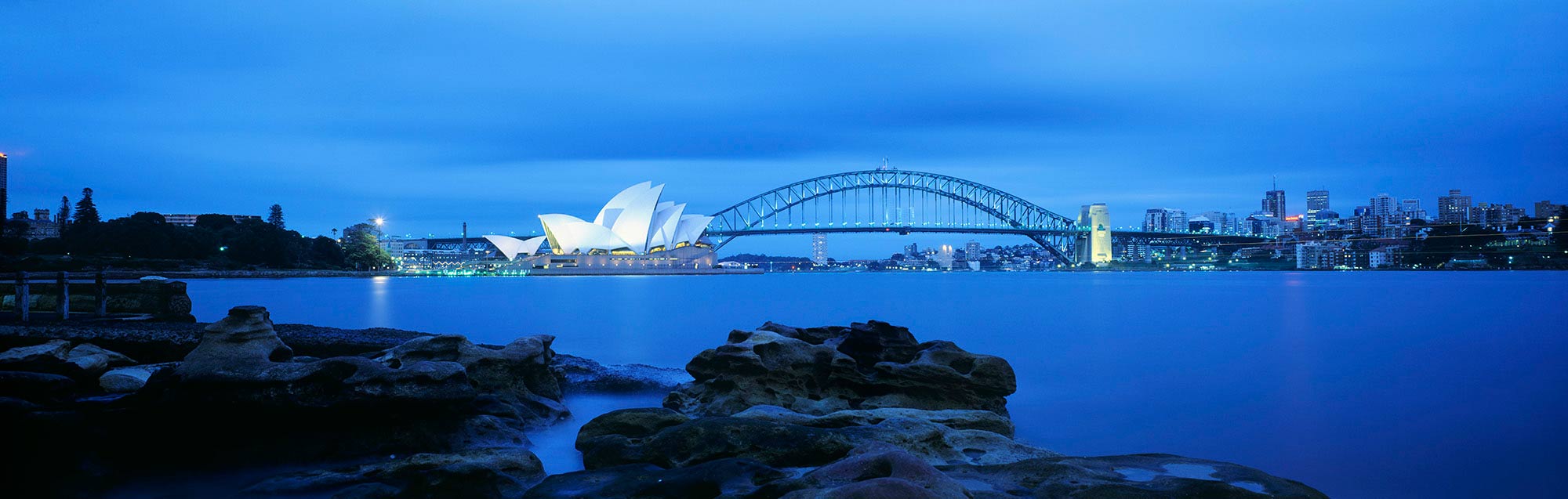 Sydney Harbour Bridge in fading light with a view of the opera house on the left.